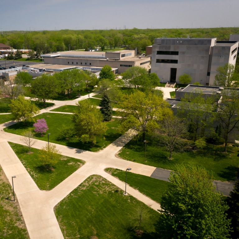 Aerial view of buildings and trees on a college campus on a sunny day.
