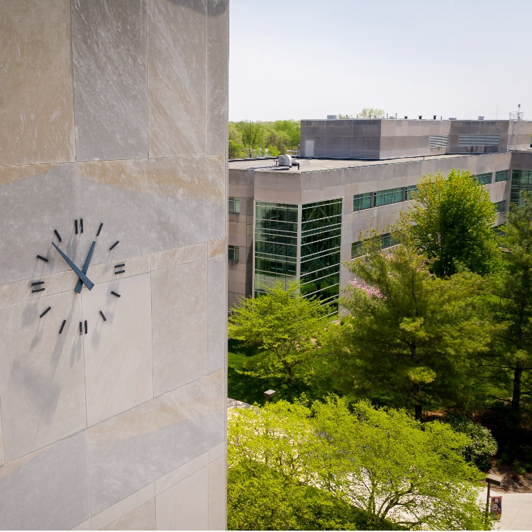 An aerial view of a clock on a limestone building. 